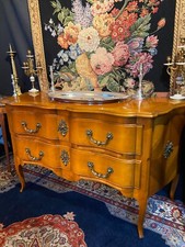 Grande commode sauteuse à façade arbalète merisier blond ornement bronze soleil