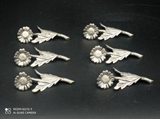 6 Portes Couteaux art déco en métal ou étain argenté fleur marguerite signé RM .