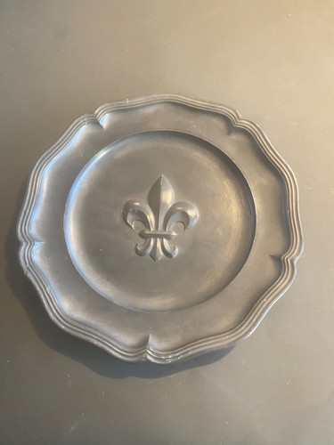 Une assiette étain décor - une,