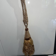 Une embrase  à rideaux . Pompon, tenture, passementerie