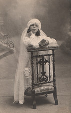 Carte-Photo Communiante accoudée sur un prie-dieu.