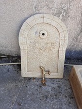 Fontaine de jardin en pierre avec fresques de vignes sur la vasque et la plaque.