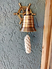 Petite cloche murale en laiton patiné , avec patère barre a roue , neuve