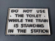 PLAQUE FONTE DO NOT USE THE TOILET WHILE THE TRAIN IS STANDING IN THE STATION 