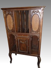 Meuble à musique en bois sculpté et canné. Portes et tiroir