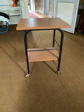 Table roulante métal noir et imitation bois. Hauteur 64cm, petit plateau 25cm. 
