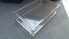 Table basse pierre vandel.. Verre biseaute. Laiton dore et pied lucite altuglass