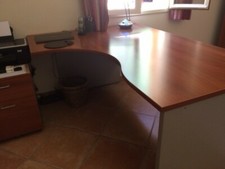 Bureau d'angle couleur noyer avec trois armoires, un caisson, un fauteuil