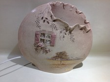 Lampe à poser plate en ceramique decor nature sous une fenêtre en relief